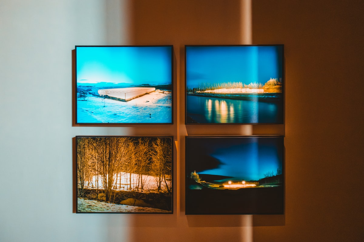 Four framed pictures displayed on a wall.