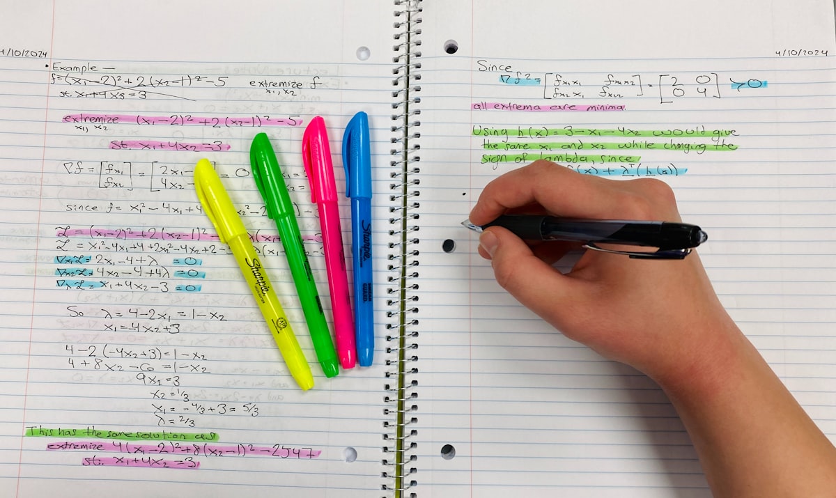 Person taking notes with pen and colorful highlighters
